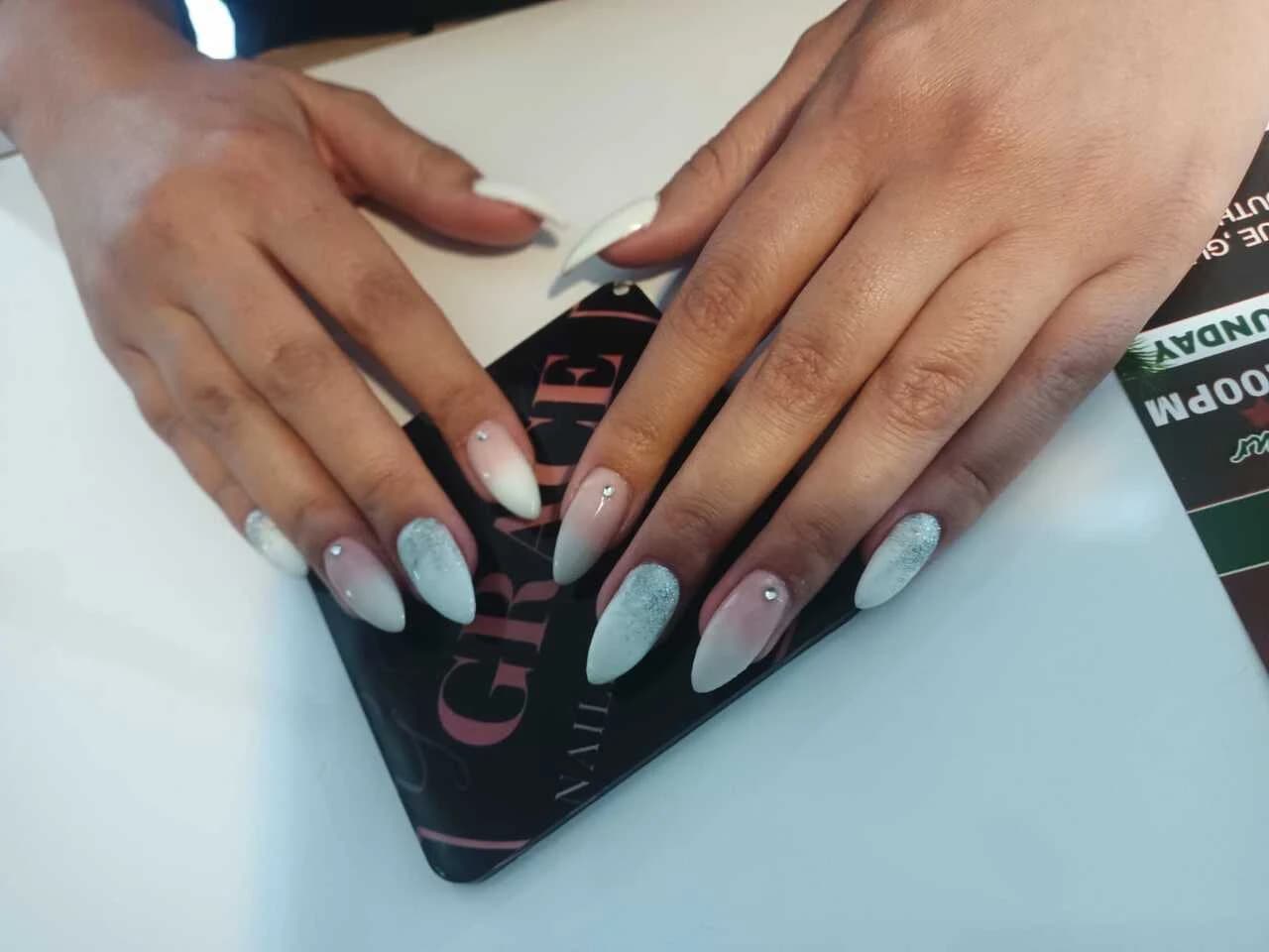 Long ombre nails in pink and white, finished with rhinestones along the cuticle.